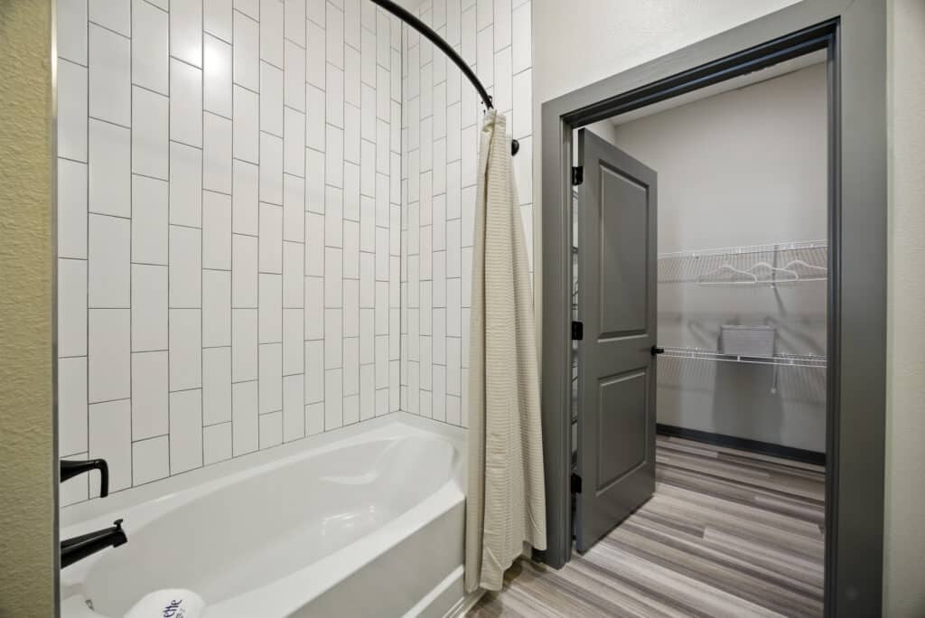 A bathroom with a shower curtain and a door.
